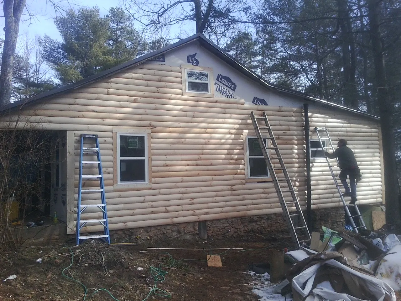 Ladders set against fresh log siding during an exterior remodel in Fort Blackmore