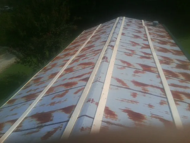 Rusted metal roof panels with new wood purlins before replacement — Storm Damage Roof Repair in Fort Blackmore by Roofing Brothers